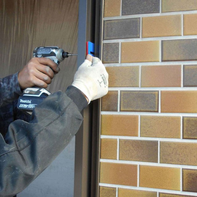 施工途中⑥：玄関ドア枠をビスで固定中。の画像