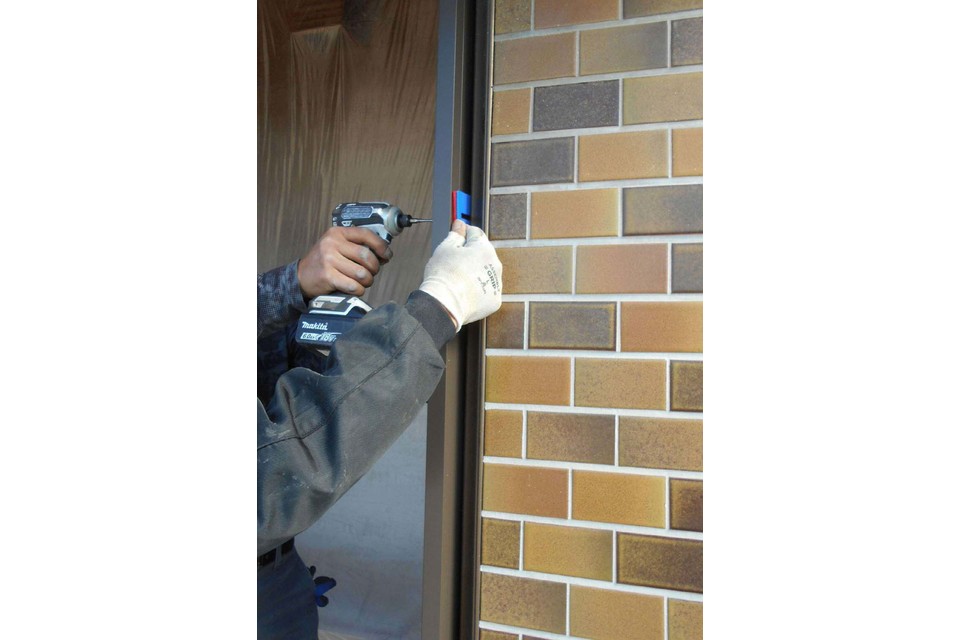 施工途中⑥：玄関ドア枠をビスで固定中。の画像